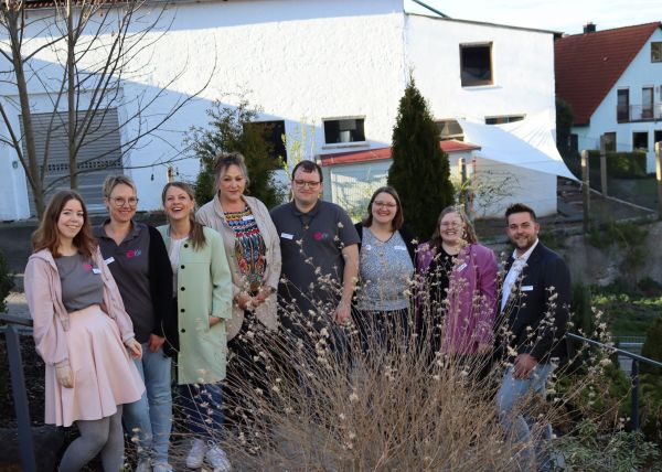 8 Personen auf einer Treppe, lächelnd, Natur im Hintergrund