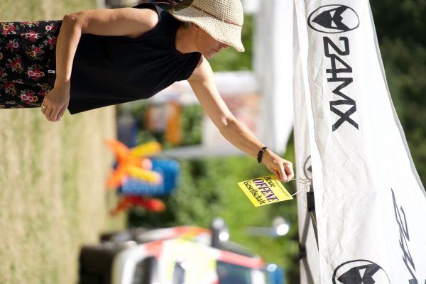 Mitarbeiterin hängt Wimbel an ihrem Stand auf