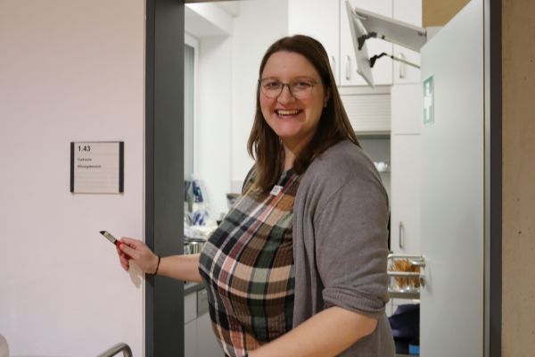 Franzi arbeitet in der Küche und lächelt in die Kamera