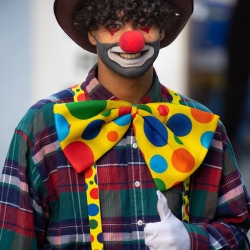 Clown hebt den Daumen hoch und lächelt in die Kamera